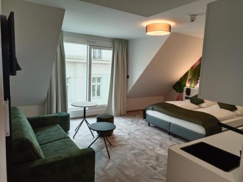 een hotelkamer met een bed en een bank bij ART-INN Design Self-Check-in-Hotel in Linz