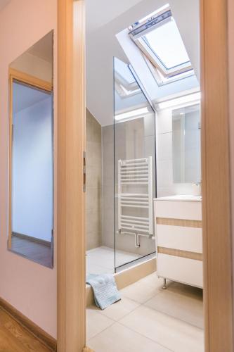 ein Badezimmer mit Waschbecken und Dachfenster in der Unterkunft Villa V in Braşov