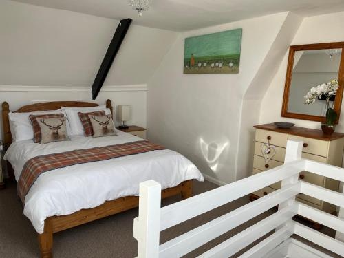 1 dormitorio con cama y espejo en Explorers Cottage, Yorkshire Wolds Character Home, en Market Weighton
