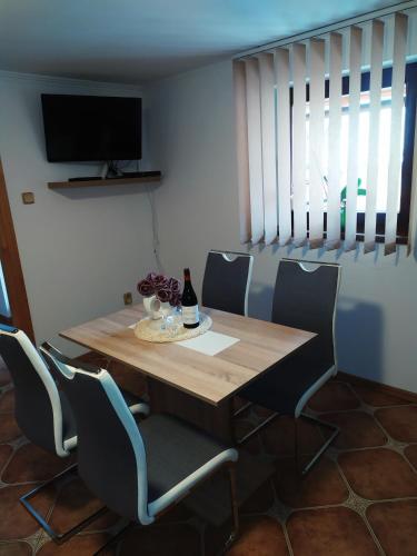 a dining room with a wooden table and chairs at Apartmány Orava - Zuberec in Zuberec