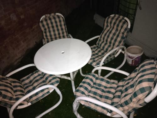 a table and two chairs and a white table and chairs at Homewood Suites Family Guest House & Apartments in Lahore