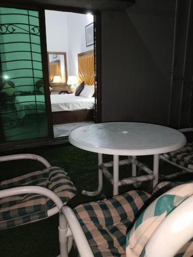 a room with a table and chairs and a bed at Homewood Suites Family Guest House & Apartments in Lahore
