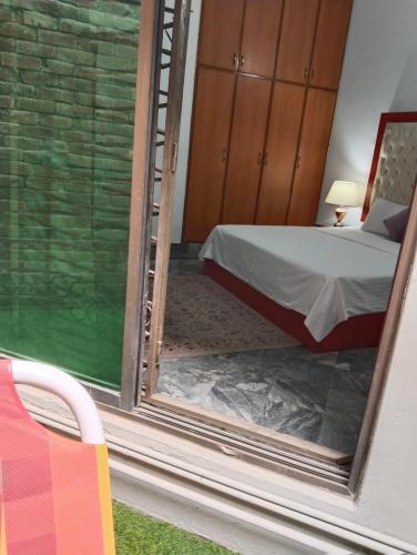 a bedroom with a bed and a ladder in a room at Homewood Suites Family Guest House & Apartments in Lahore
