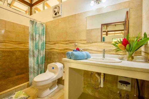 a bathroom with a toilet and a sink and a shower at Peace Garden Spacious Bungalows- a walk to the beach in Cocles