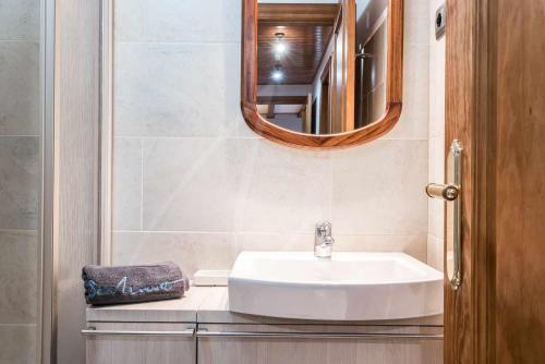 a bathroom with a sink and a mirror at Riu Nere by SeaMount Rentals in Vielha