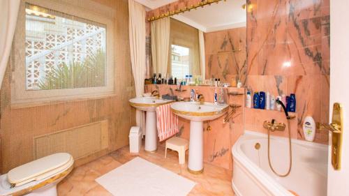 a bathroom with two sinks and a tub and a toilet at Villa Vistabella in Chayofa