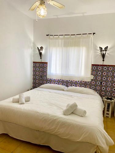 a bedroom with a large white bed with a window at Poniente in Barbate