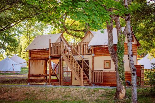 een groot houten huis met een trap ervoor bij Whaka Lodge in Seissan