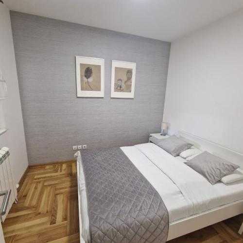 a bedroom with a bed and two pictures on the wall at M48 apartments in Belgrade