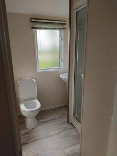 a bathroom with a toilet and a window at Vault 21 in Millom