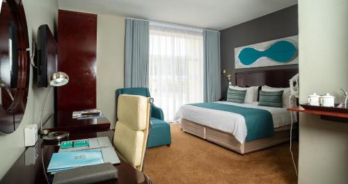 Tlotlo Hotel & Conference Centre في غابورون: غرفة في الفندق مع غرفة نوم مع سرير ومكتب
