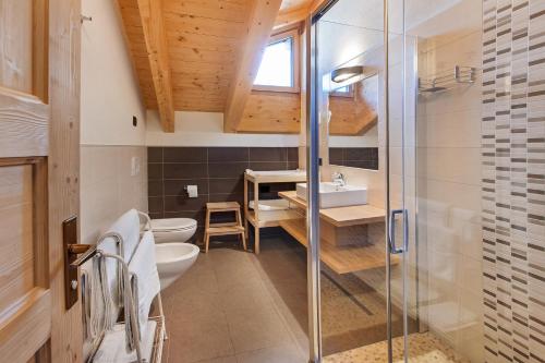 y baño con ducha, aseo y lavamanos. en Appartamento Family Engadina Chalet en Livigno