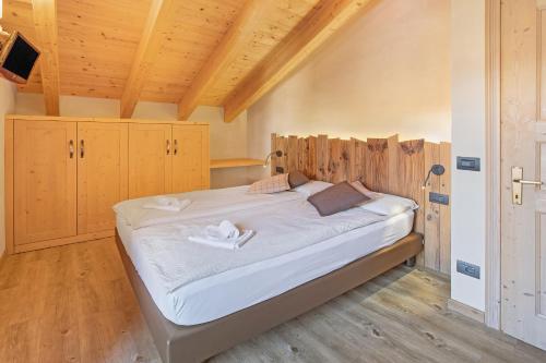 uma cama grande num quarto com tectos em madeira em Appartamento Family Engadina Chalet em Livigno