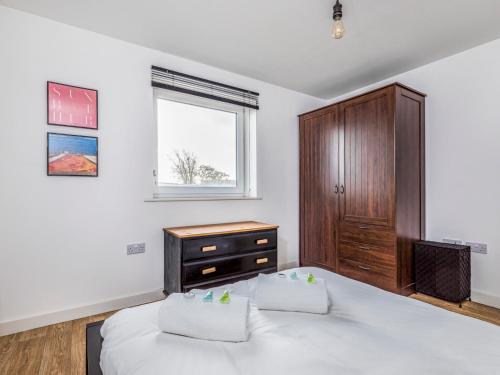 a bedroom with a bed and a dresser and a window at Pass the Keys Central Modern Flat with Parking in Chichester