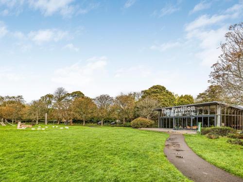 a building in a park with a grass field at Pass the Keys Central Modern Flat with Parking in Chichester