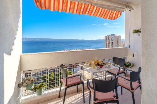 een balkon met een tafel en stoelen en uitzicht op de oceaan bij Apartment Zest in Split