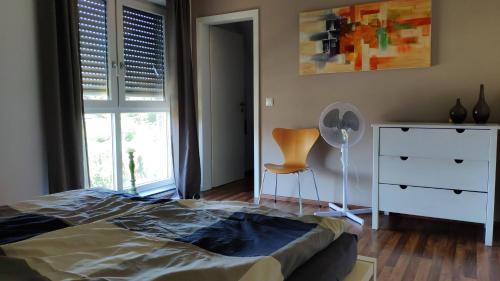 um quarto com uma cama, uma cómoda e uma cadeira em Ferienhaus-Kalkar em Kalkar