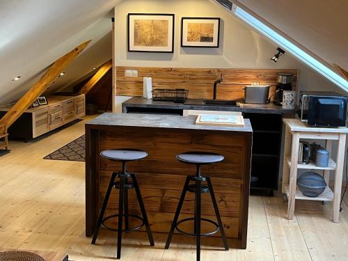 a kitchen with a counter and stools in a room at Siedlisko na Górce in Zalec