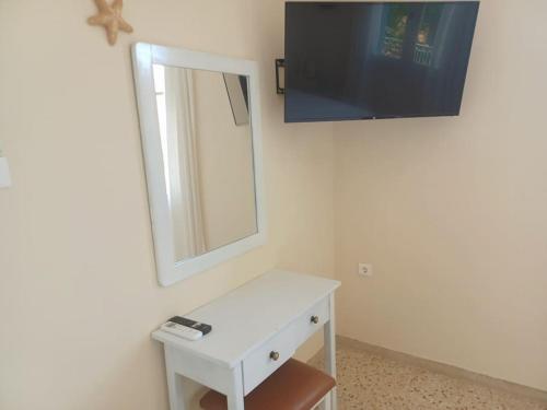 a white dresser with a mirror and a tv at Big apartment on the beach in Tolo