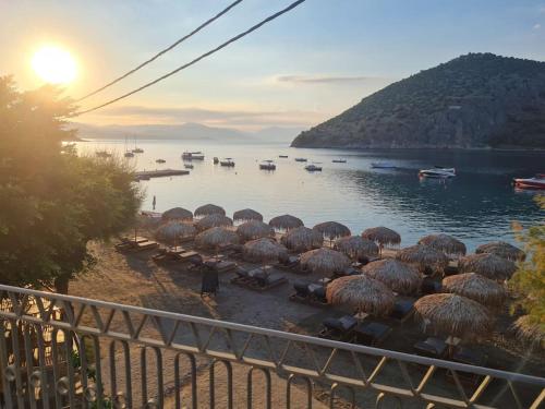 a group of straw umbrellas on the shore of a lake at Big apartment on the beach in Tolo