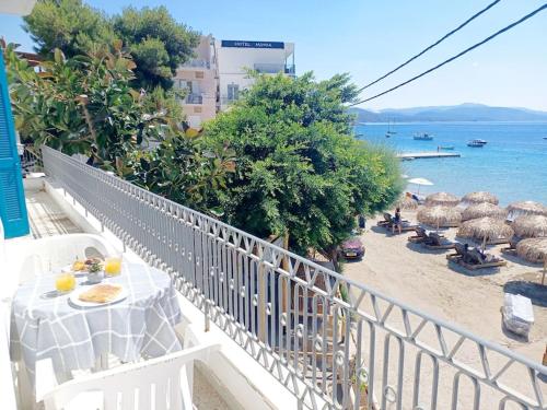 a balcony with a table and umbrellas on a beach at Big apartment on the beach in Tolo