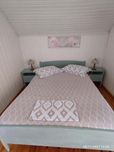 a bedroom with a bed with pink and white sheets and pillows at Σοφίτα Μαρτά in Kalamos