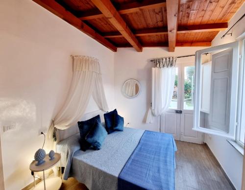 Stazzo San Teodoro في سان تيودورو: غرفة نوم مع سرير ووسائد زرقاء