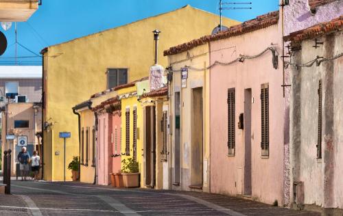 a street with colorful buildings on a street at Gabbiano Azzurro Hotel & Suites in Golfo Aranci