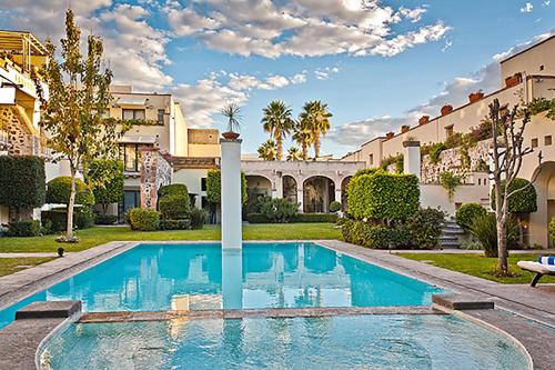 a swimming pool in front of a villa at Doña Urraca Hotel & Spa in Querétaro