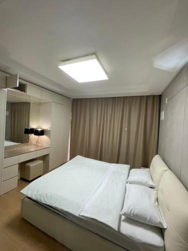 a bedroom with a white bed and a mirror at Happy Days at Highvill G in Promyshlennyy