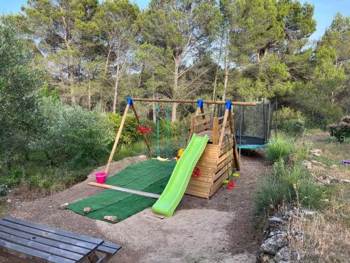 a playground with a slide and a swing set at DOMAINE MAXXIM in Clermont-lʼHérault