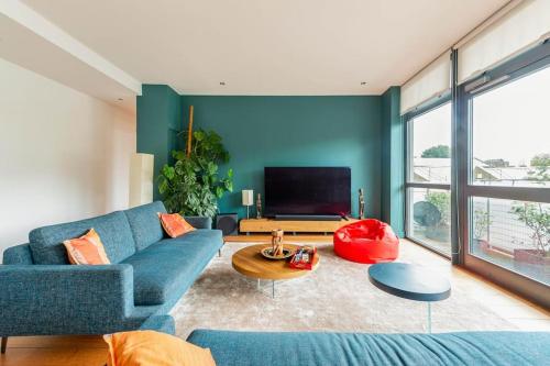 a living room with a blue couch and a tv at Luxurious flat sunny, quiet, design, lift, balcony in London