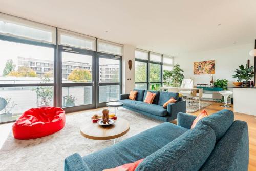 a living room with two blue couches and a table at Luxurious flat sunny, quiet, design, lift, balcony in London