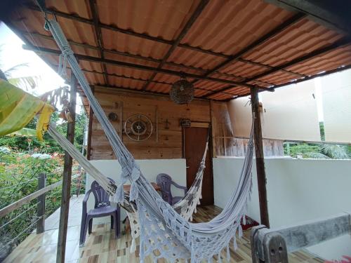 a hammock on the porch of a house at Hospedaria Recanto da Paz in Itaporanga dʼAjuda