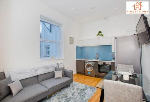 uma sala de estar com um sofá e uma cozinha em Top-Spec & Sublime - City Centre - Newbuild - 5* em Bridgwater