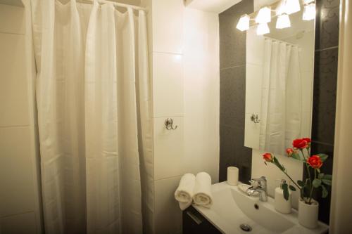 a bathroom with a white shower curtain and a sink at Apollonio Upper View Suites in Korinthos