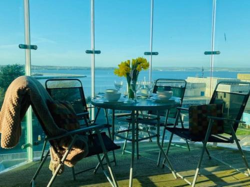 a woman sitting at a table on a balcony at Seascape Apartment in Portland