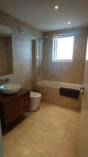 a bathroom with a tub and a sink and a toilet at Seascape Apartment in Portland