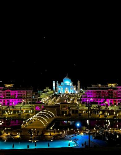 a city at night with a building with purple lights at Duplex apartment in Porto Sharm El skeikh in Sharm El Sheikh
