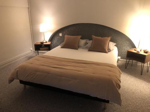 une chambre avec un grand lit avec une grande tête de lit dans l'établissement Loft Royal des Promenades, à Reims