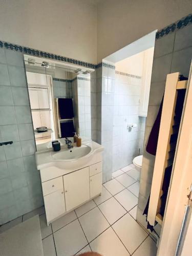 a white bathroom with a sink and a toilet at Descent Unit in Fontainebleau in Fontainebleau