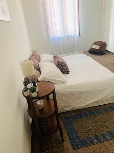 - une chambre avec un lit et une table avec une lampe dans l'établissement Incantevole mini appartamento in centro a Padova., à Padoue