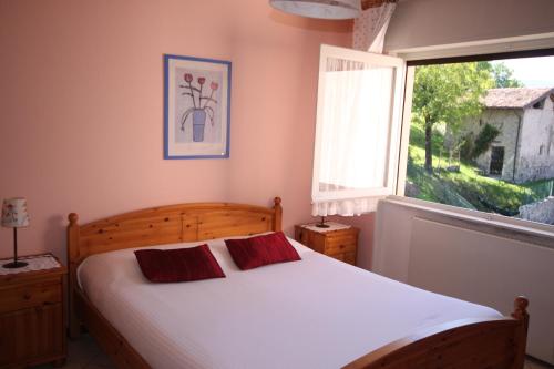 um quarto com uma cama grande e uma janela em Balcone Fiorito em Menaggio
