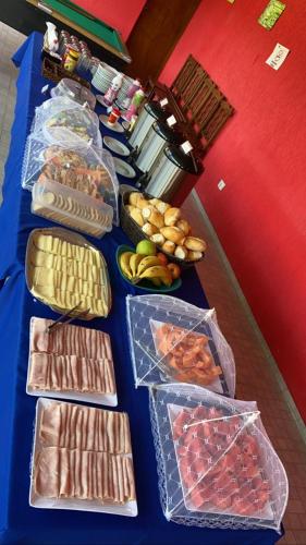 a blue table topped with lots of different types of food at Pousada Recanto dos Maximianos in Jarinu