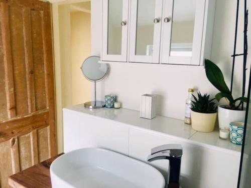 a bathroom with a white sink and a mirror at Spacious Victorian townhouse with Cathedral views in Lincoln