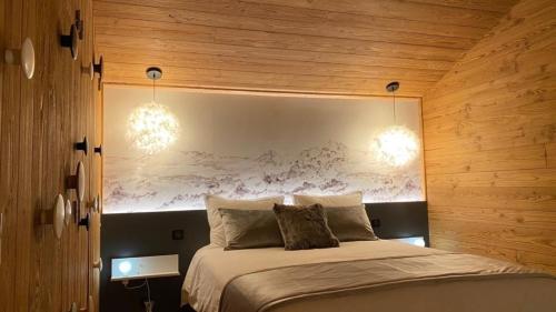 a bedroom with a large bed with wooden walls at Chalet Jardin Alpin Valberg in Péone
