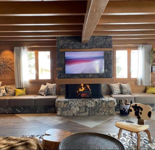a living room with a fireplace and a flat screen tv at Chalet Jardin Alpin Valberg in Péone