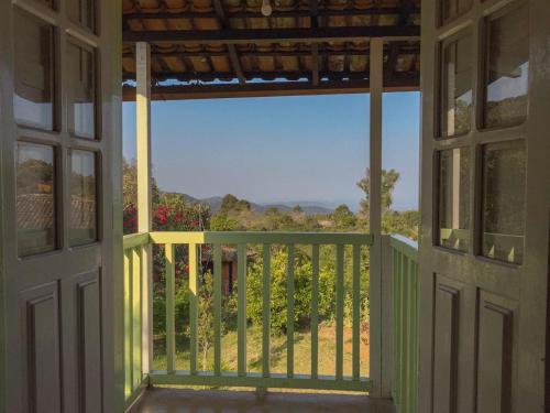 an open door to a balcony with a view at Chalés Lavras de Minas - Brasil in Lavras Novas