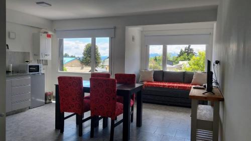 sala de estar con mesa, sillas y sofá en Departamento con vista al lago y cerros en San Carlos de Bariloche