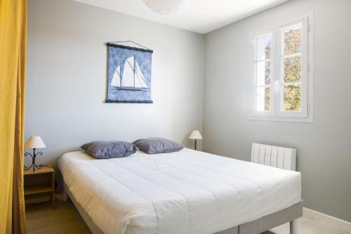 a bedroom with a white bed with a sail on the wall at CAP O SUD grande maison avec Piscine à St Martin de Ré in Saint-Martin-de-Ré